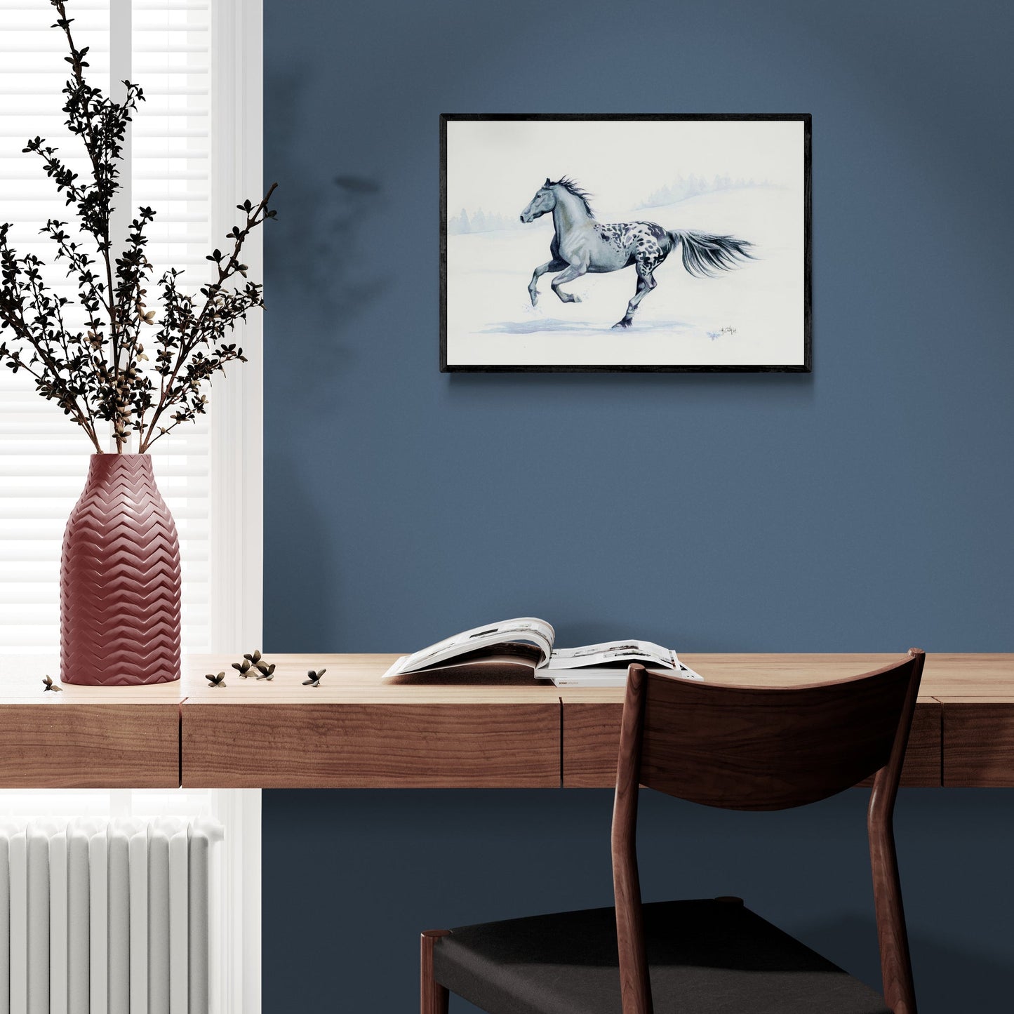 Framed artwork of a horse on a blue wall above a wooden desk.